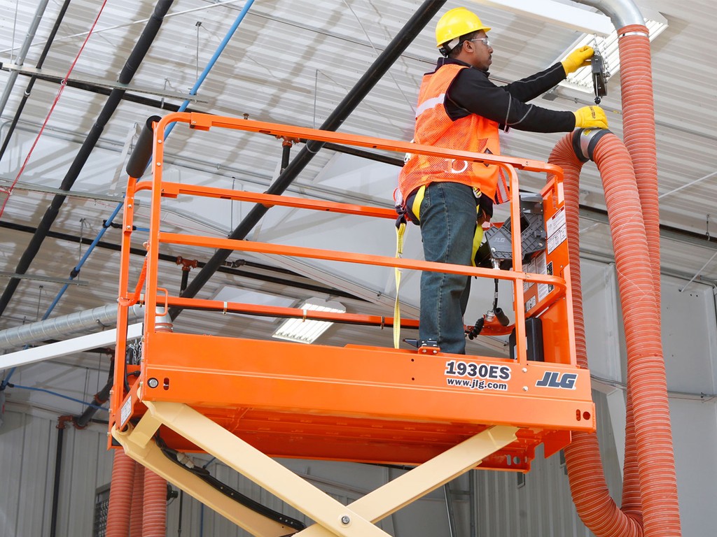 man doing electrical maintenance on a JLG1930ES Scissor Lift